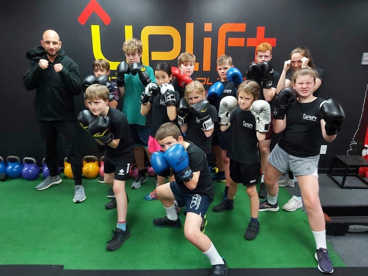 The Future Stars kids crew with gloves on in front of the Uplift wall
